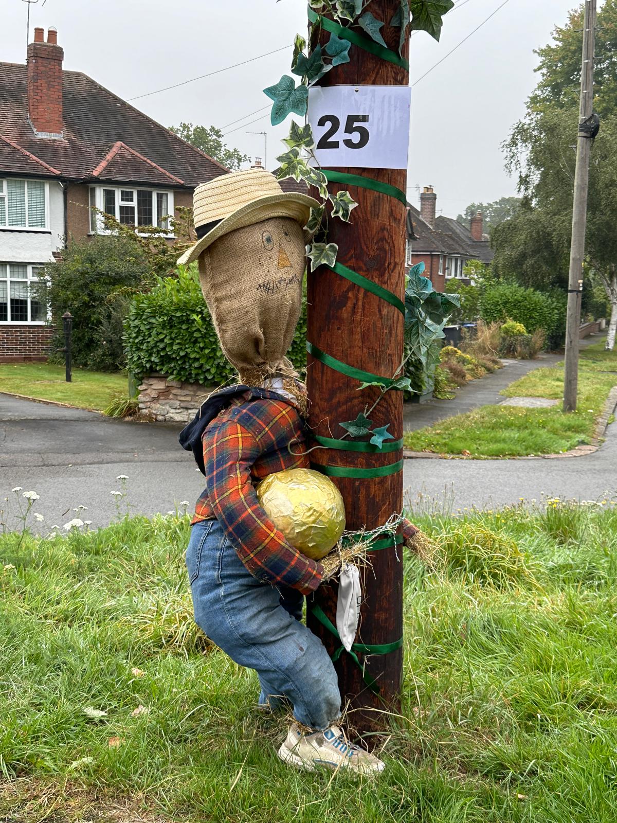 Scarecrow hugging a lamppost